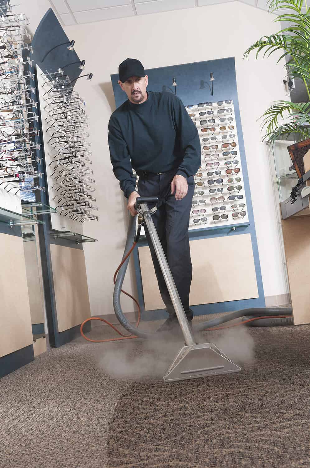 Man steam cleaning the carpet in an optometry office.