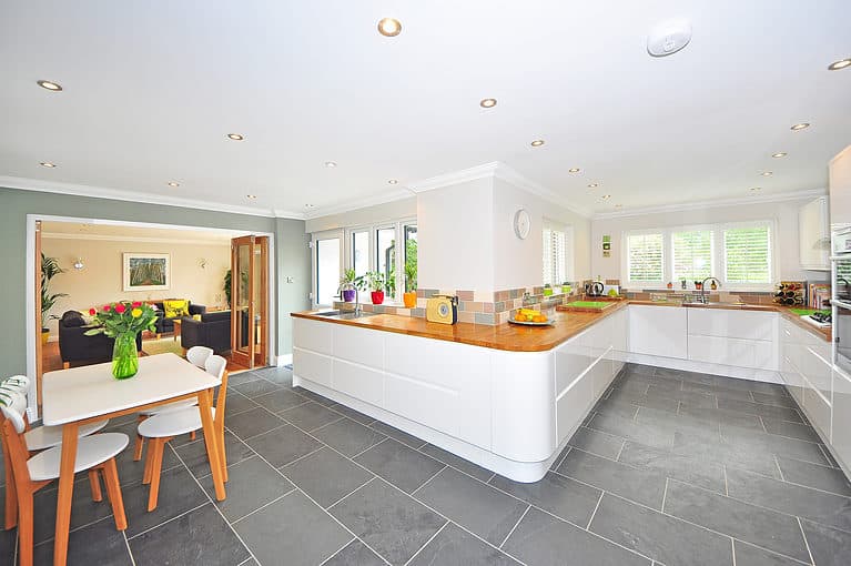 Bright, spacious Australian kitchen with white cabinetry, wooden benchtops, and large windows for natural light.