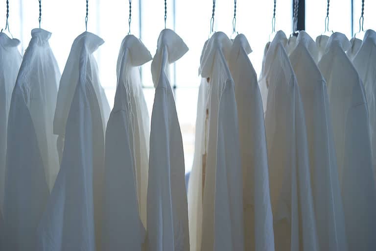clean white shirts hanging on hangers to dry