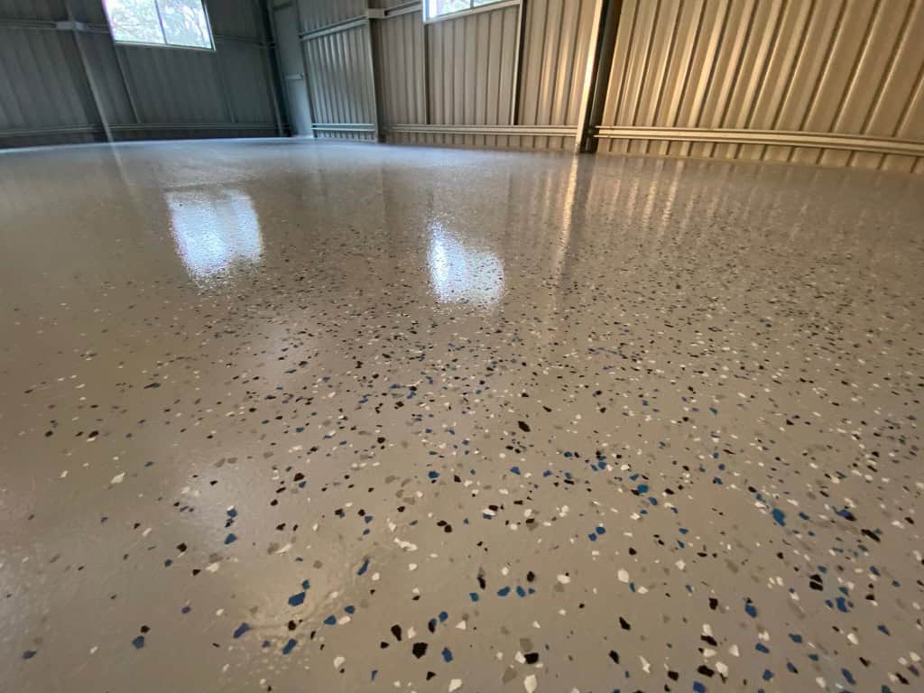 High-gloss epoxy polished concrete flooring in industrial warehouse setting.