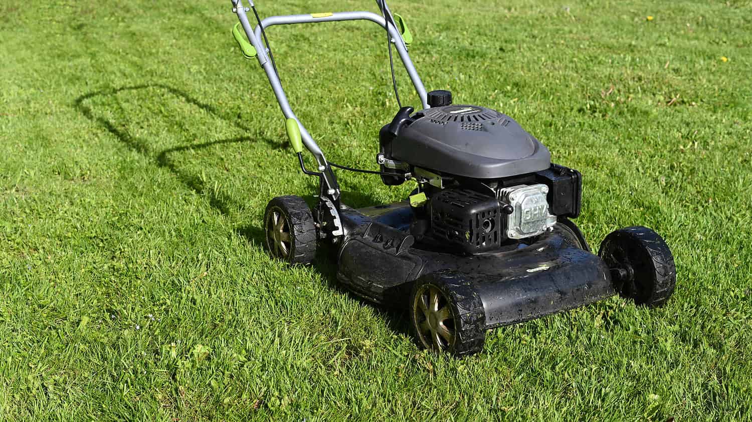 Petrol powered lawnmower on freshly mowed grass