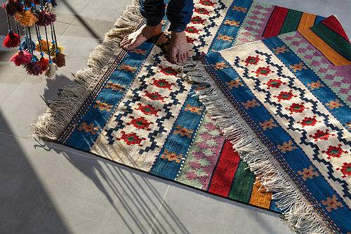 Vibrant patchwork rug with geometric patterns and tassel edges, ideal for home decor.